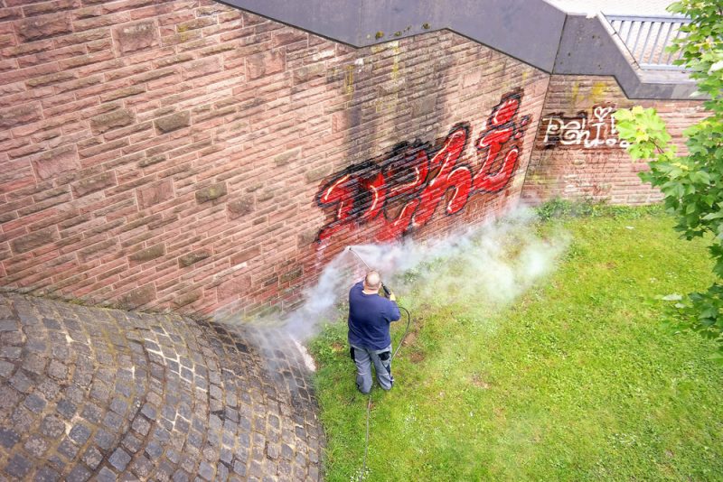 A worker washes a wall